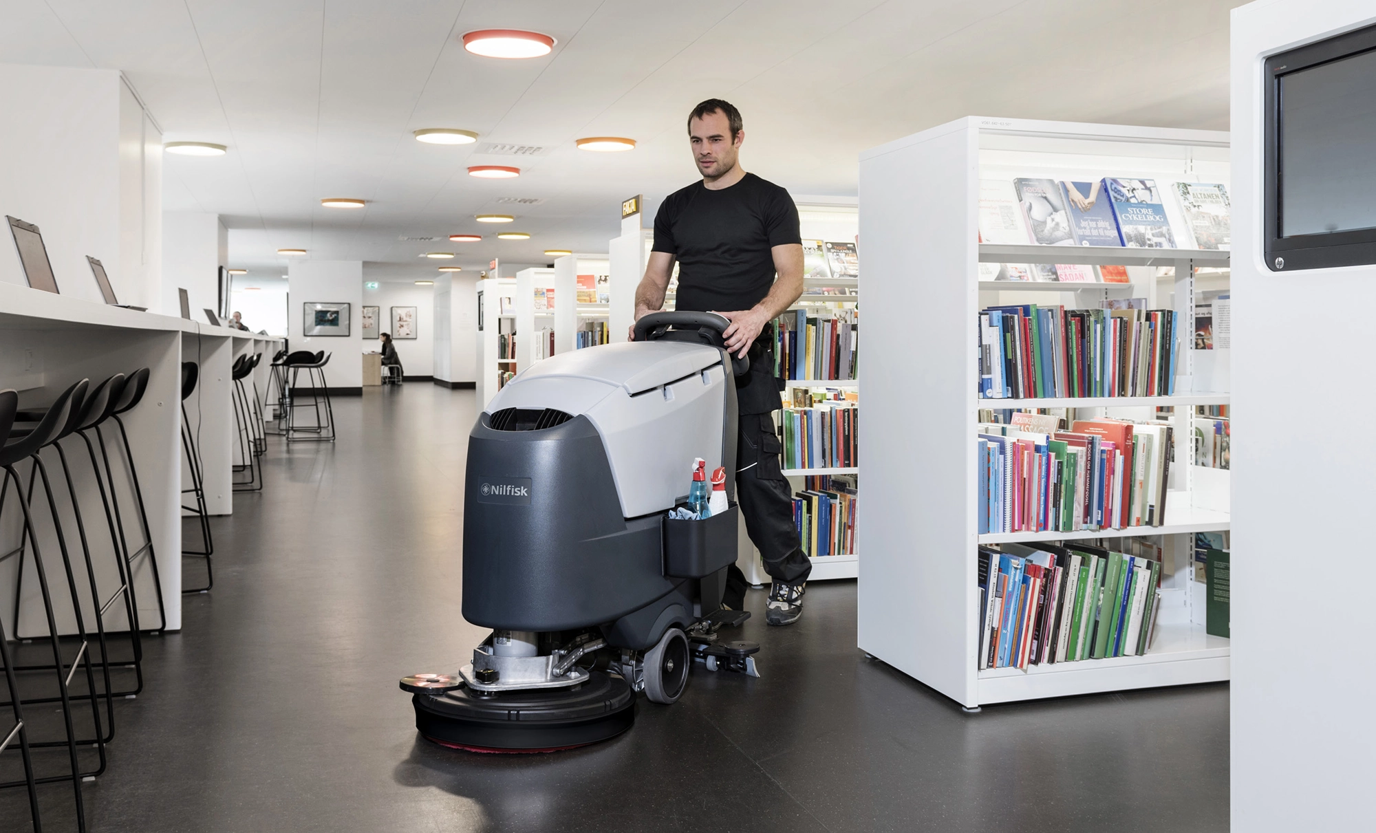Man using Nilfisk Autoscrubber in a Library setting
